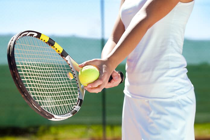 Kvinde spiller tennis med ketcher og bold